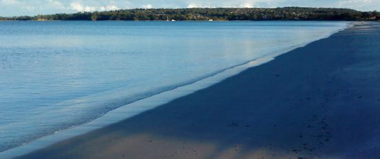 Waves on a beach, washing away a loved one's name written in the sand