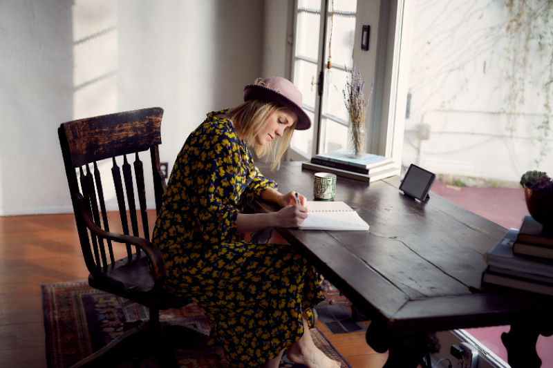 Lady at a table writing a grief journal