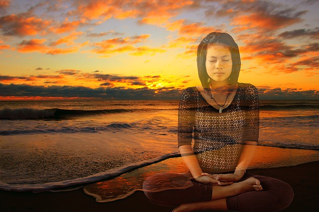 Woman meditating on the beach