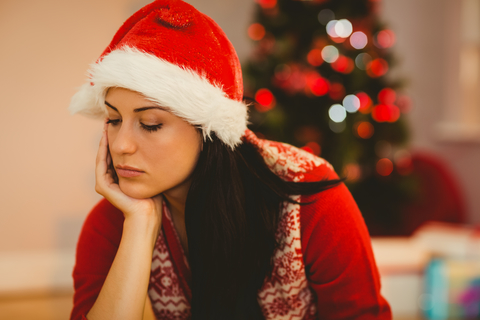 woman feeling grief at xmas wearing a santa hat