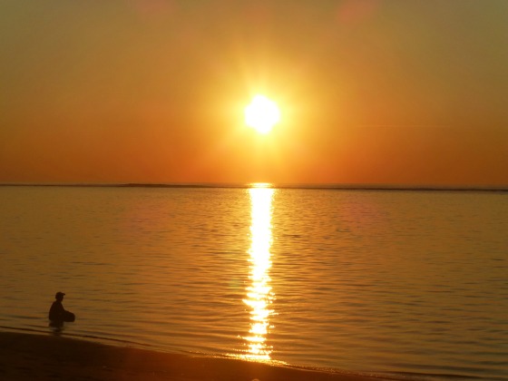 Woman looking at the sunrise to illustrate finding joy after grief