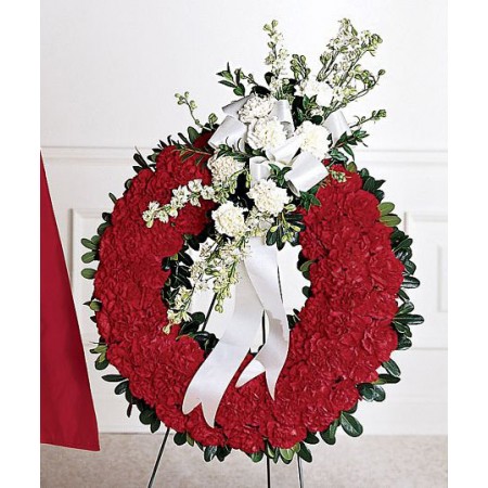 Military funeral flowers, a circular red wreath with crest.