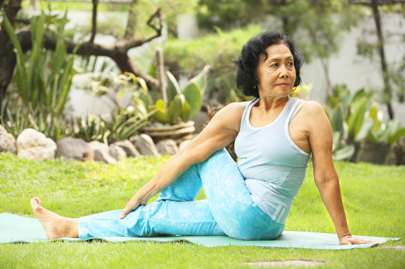 Older lady doing yoga in a park