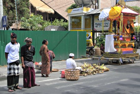 Balinese sitting in the street preparing for a cremation
